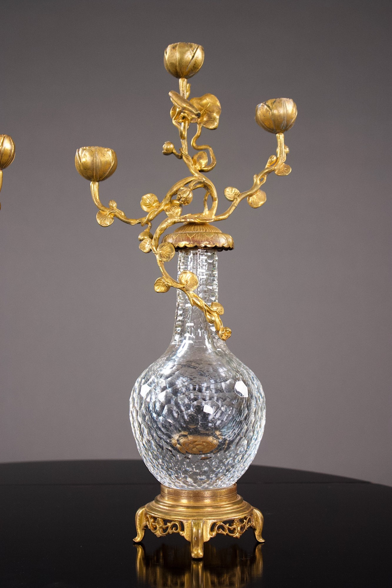 One of the pair of crystal and gilt-bronze candelabra